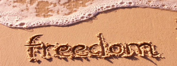Freedom written in the sand at a beach